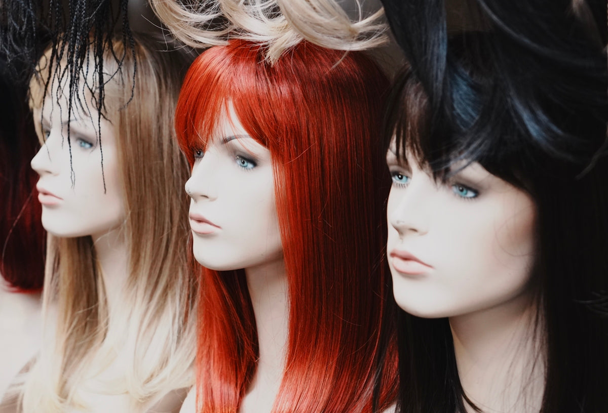 Mannequins showcase wigs of different colors.