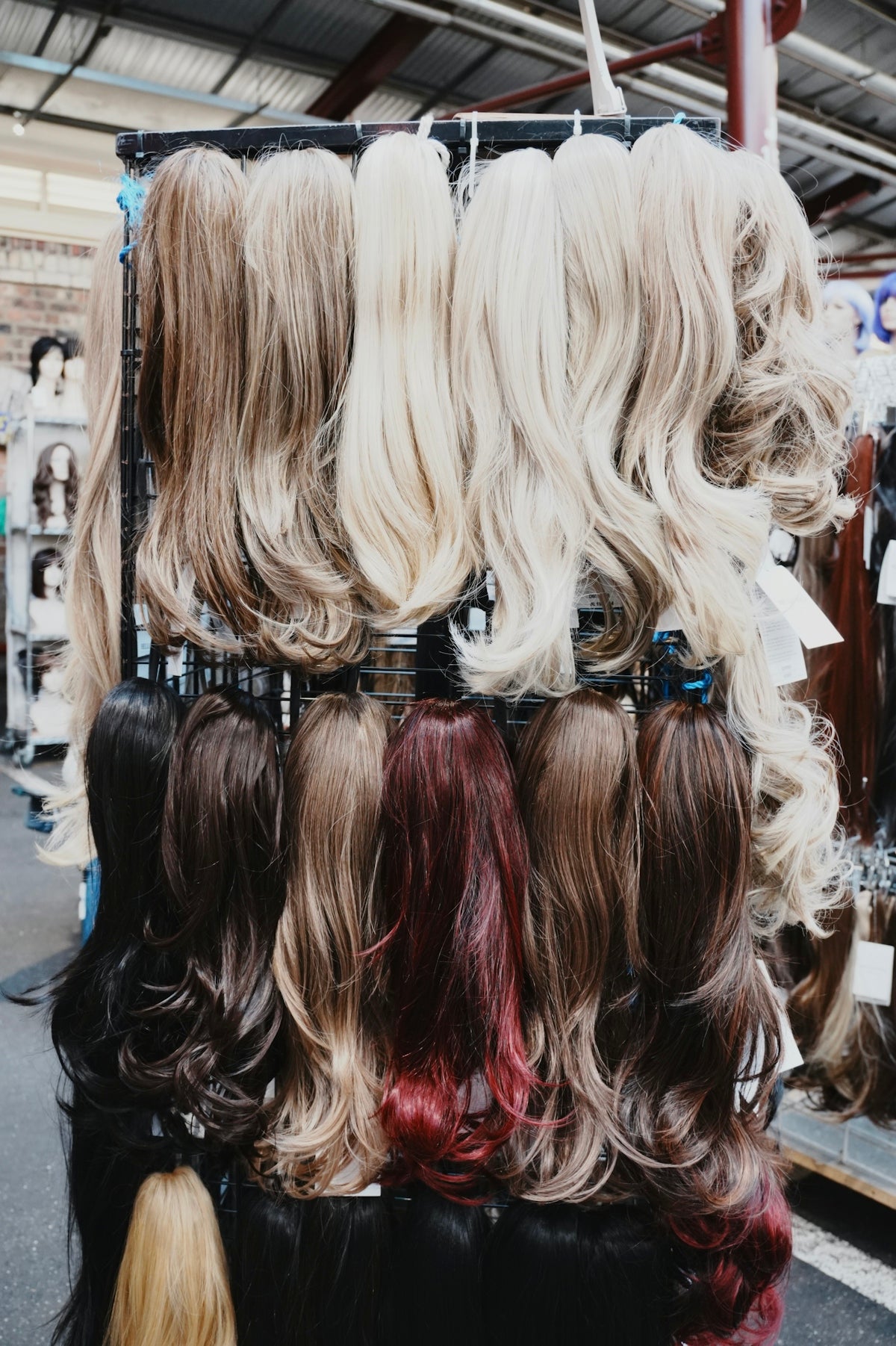 Wigs of various colors are displayed