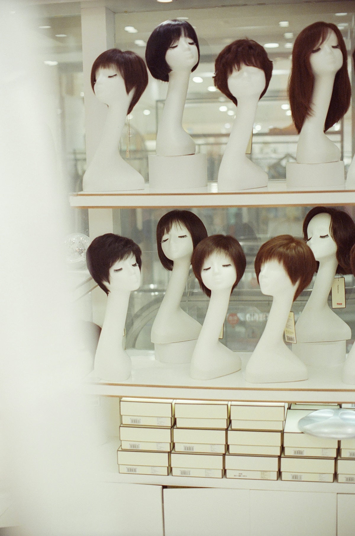 Mannequins display various wigs on shelves