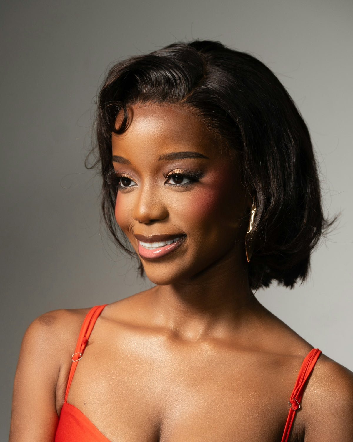 Young black woman with short hair wearing red dress.